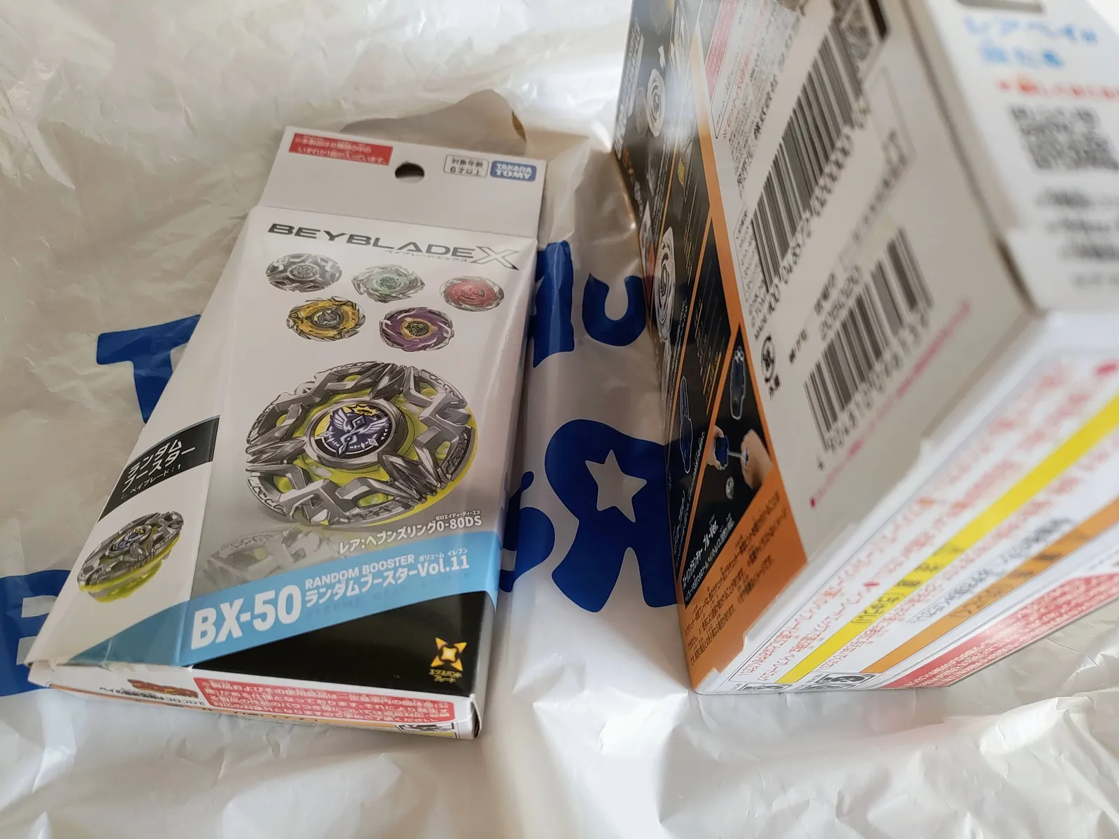 トイザらスの袋の上に置いた、この日買った2点。ランダムブースターVol.11(BX-50)とグローリーワルキューレ(UX-20)の箱
