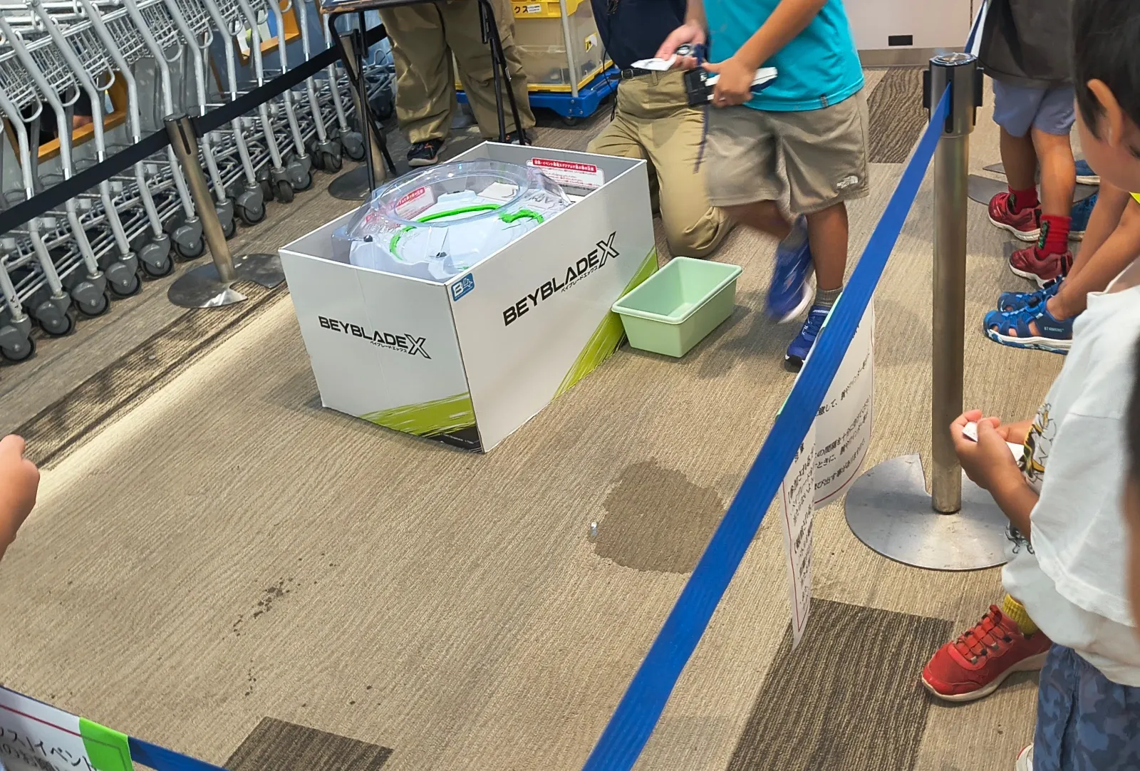 イベント用のBEYBLADE Xスタジアムを、ロープの外から見守る子どもたち