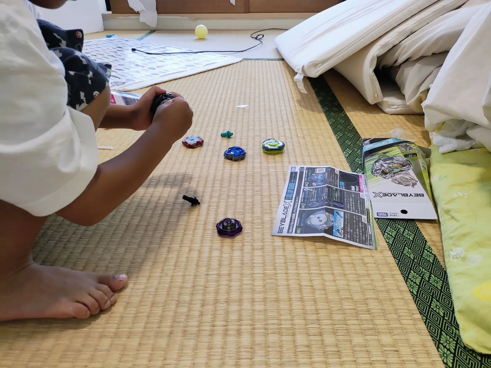 畳の部屋で子どもがベイを組み立てている