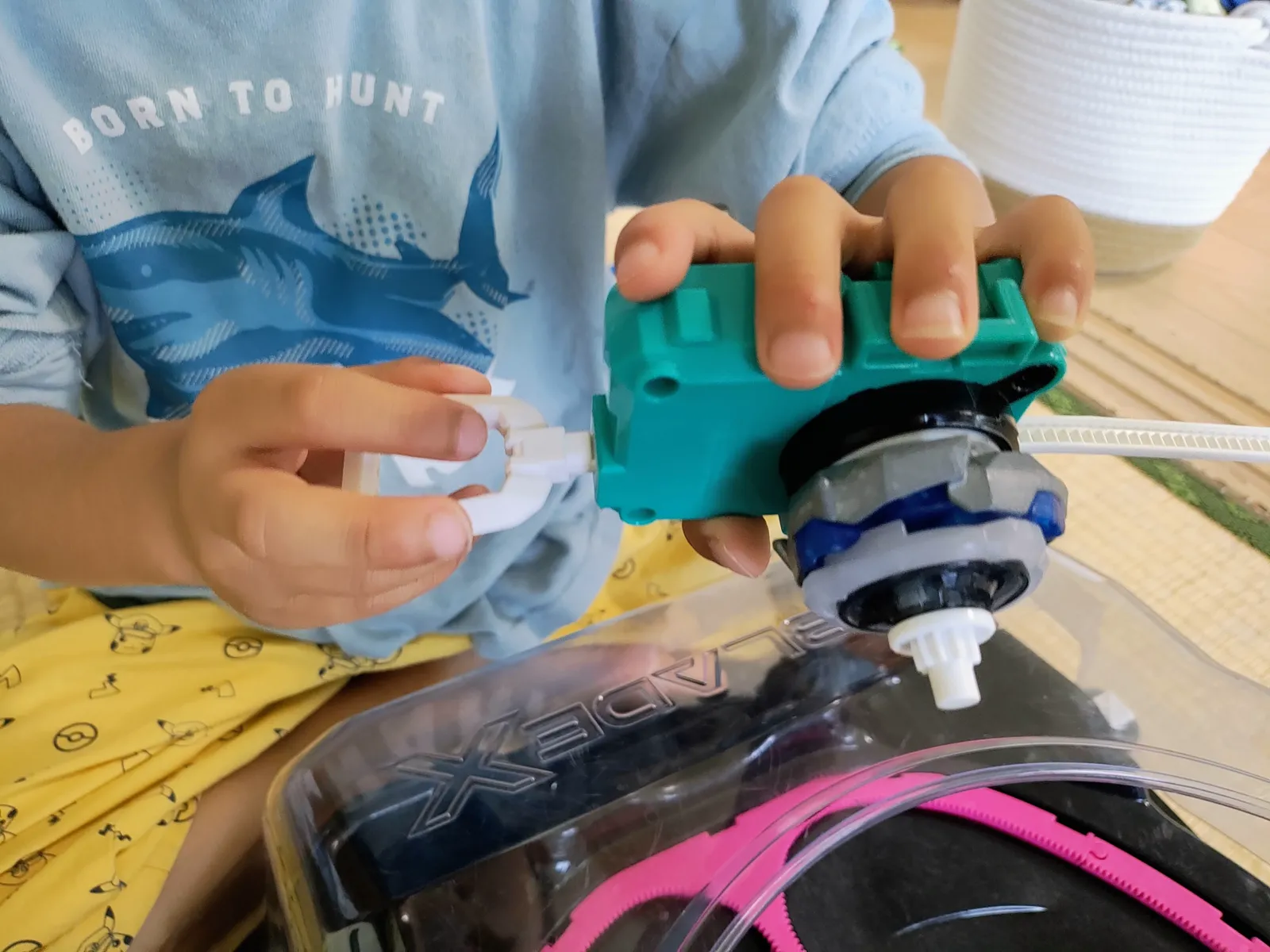 年少の子どもがワインダーランチャーにベイをセットしているところ